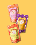 Drei verschiedene Curry Pasten von Karma Food – Curry Paste, Korma Paste und Madras Paste – auf gelbem Hintergrund, perfekt für authentische indische Gerichte