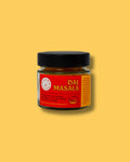Glas Dal Masala Gewürzmischung von Karma Food auf gelbem Hintergrund, nach traditionellem Familienrezept