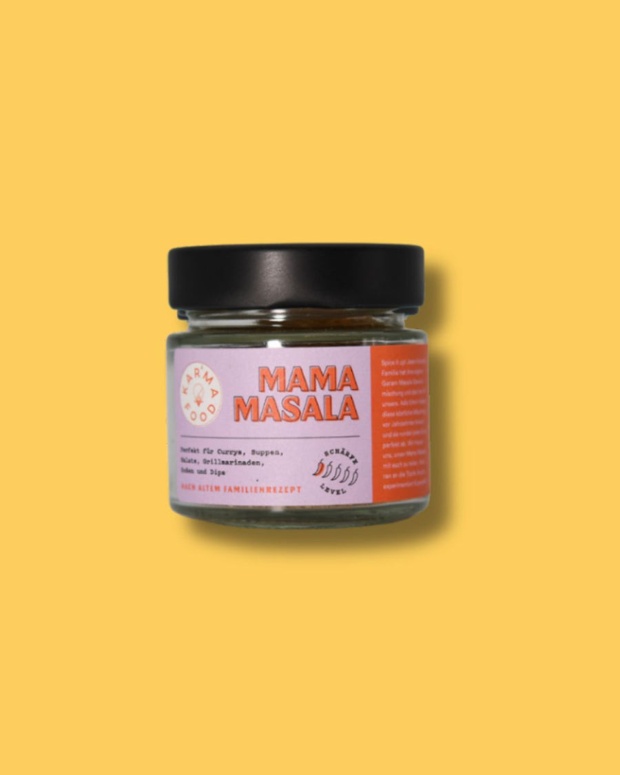 Glas Mama Masala Gewürzmischung von Karma Food auf gelbem Hintergrund. Etikett zeigt Schärfegrad und Verwendungszwecke wie Currys, Suppen und Dips