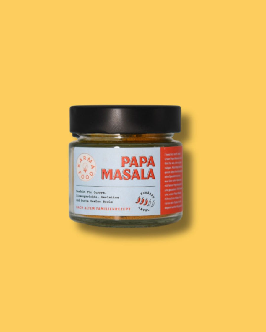 Glas Papa Masala Gewürzmischung von Karma Food auf gelbem Hintergrund. Perfekt für Currys, Eintopfgerichte, Omeletts und bunte Gemüse Bowls, nach traditionellem Familienrezept