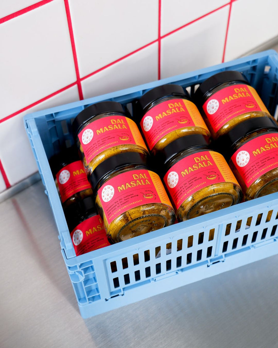 Mehrere Gläser Dal Masala Gewürzmischung von Karma Food in einer blauen Kiste, bereit für den Versand oder Verkauf