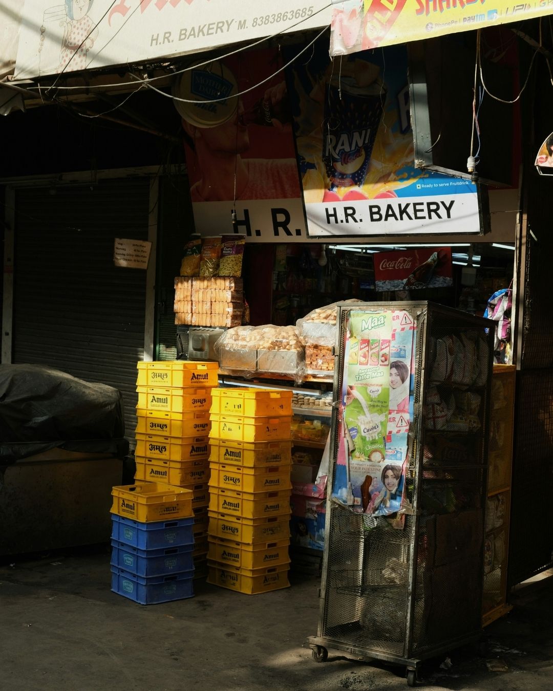 Typische indische Straßenbäckerei mit gestapelten Amul-Kisten und Waren in der Auslage