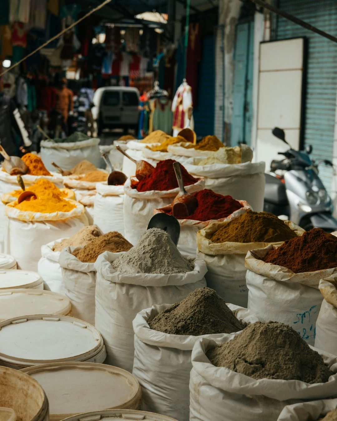 Indischer Marktstand mit offenen Säcken voller bunter Gewürze wie Kurkuma, Chili und Kreuzkümmel