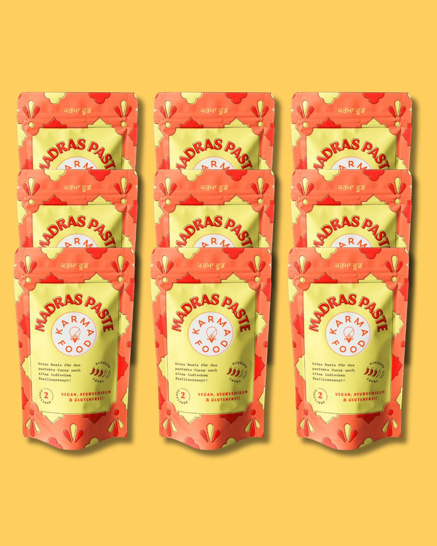 Madras Paste von Karma Food in roter Verpackung mit gelbem Hintergrund, vegane ayurvedische Curry-Paste für authentischen Geschmack